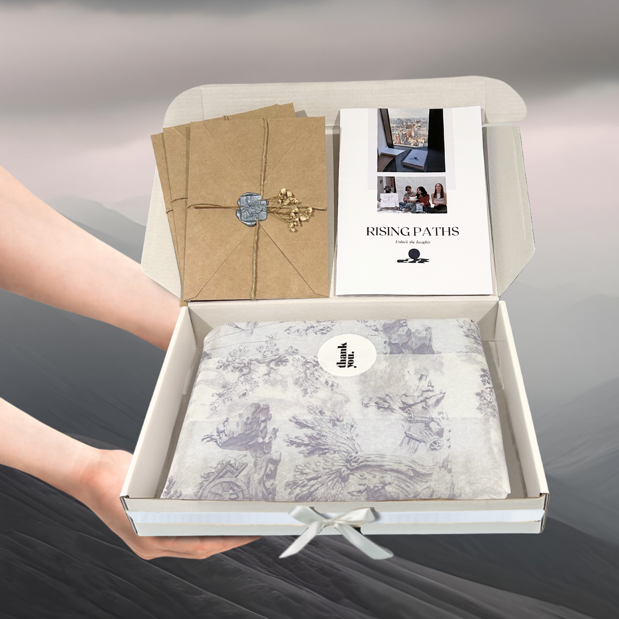 Open box containing stationery items with a 'Rising Paths' brand label.